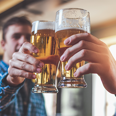 Zwei Männer stoßen gemeinsam mit Biergläsern an