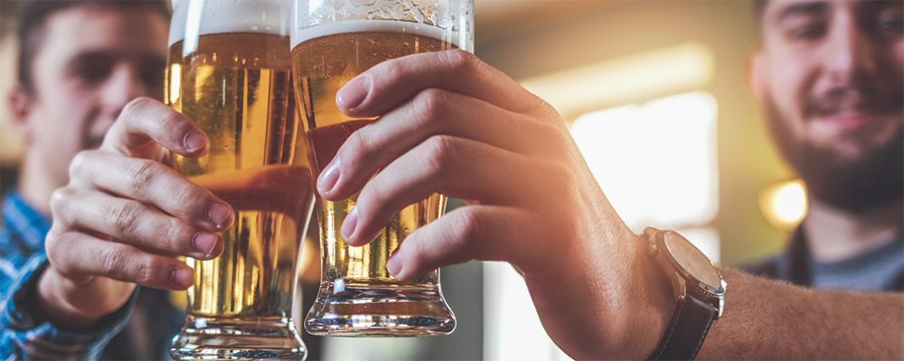 Zwei Männer beim gemeinsamen Anstoßen mit Biergläsern