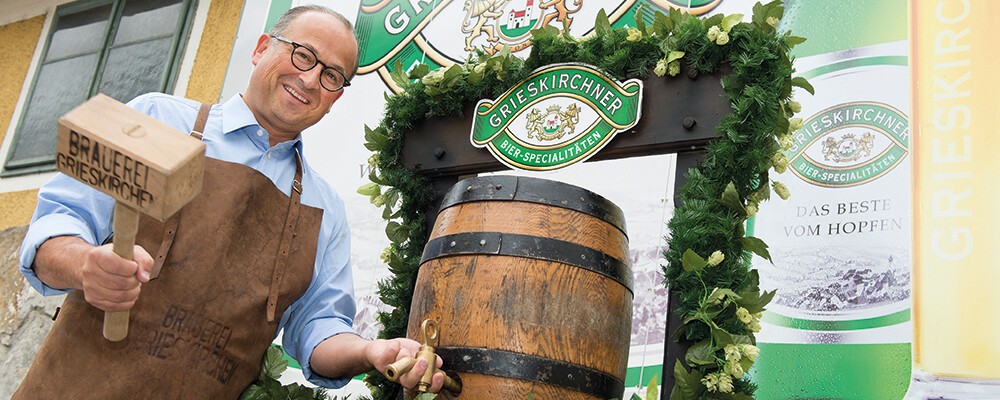Ein Mitarbeiter vom Grieskirchner Bier neben einem Fass Bier