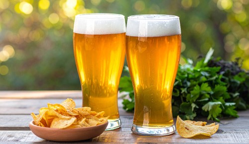 Zwei volle Biergläser nebeneinander auf einem Tisch
