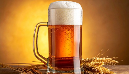 Ein mit Bier gefüllter Masskrug auf einem hölzernen Untergrund