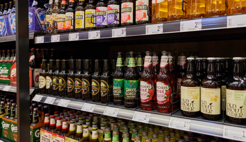 Mehrere verschiedene Bierflaschen in einem Regal eines INTERSPAR-Marktes