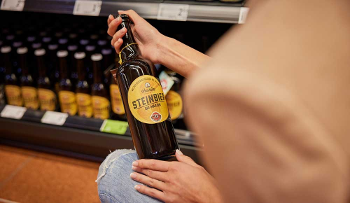 Detailaufnahme einer Craft Beer-Flasche in den Händen einer Person