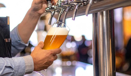 Eine Person beim Zapfen von Bier aus einem Zapfhahn