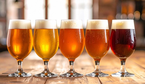 Mehrere volle Biergläsern mit Bier in unterschiedlichen Farbtönen nebeneinander