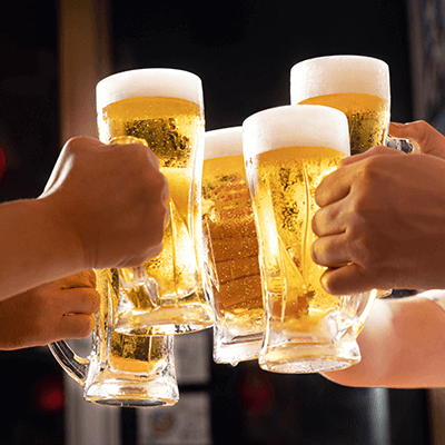 Mehrere Personen stoßen mit vollen Biergläsern an