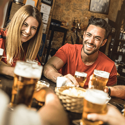 Mehrere Personen mit gefüllten Biergläsern an einem Tisch