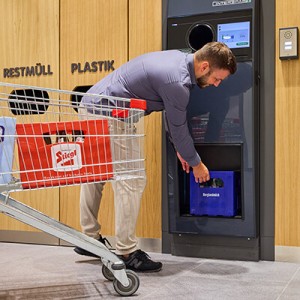 Ein Mann bei der Rückgabe eines Bier-Kartons  bei einem INTERSPAR-Pfandrückgabegerät