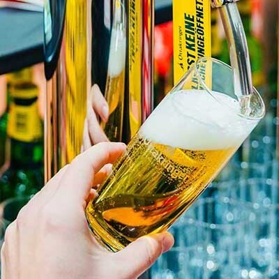 Bier wird aus einem Zapfhahn in ein Bierglas geschenkt