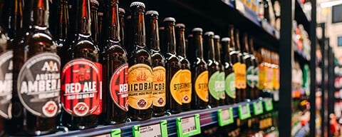 Mehrere verschiedene Bierflaschen in einem Regal in einem INTERSPAR-Hypermarkt