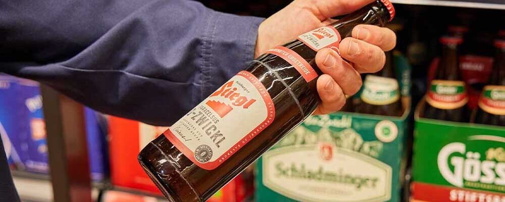 Ein Mann hält eine Flasche Bier in der Hand
