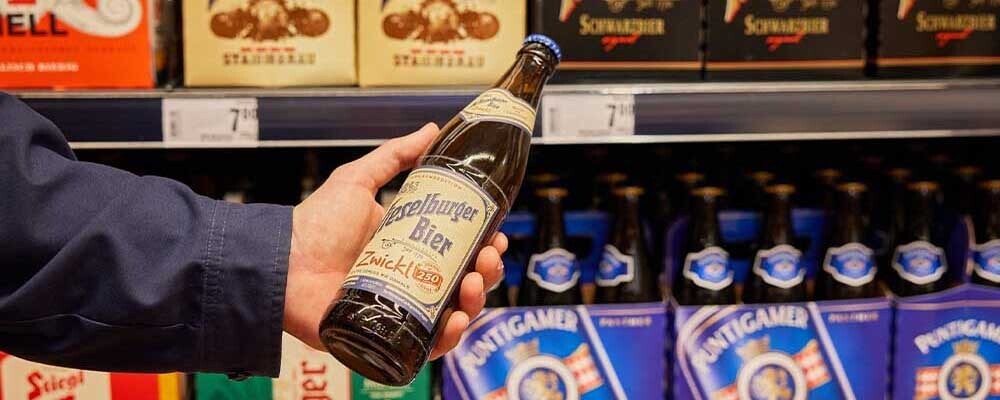 Ein Mann hält eine Flasche Bier in der Hand