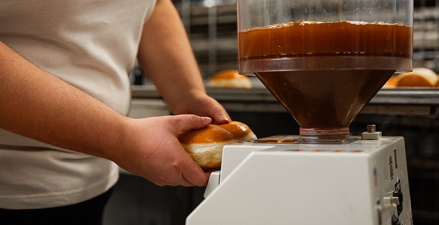 Krapfen wird befüllt mit Marillenmarmelade.