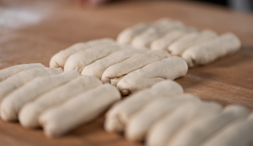 Frische Bäckerzeilen beim Rasten nebeneinander auf einem Brett