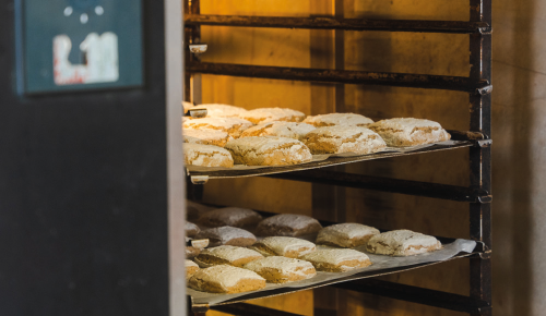 Frische Bio-Roggenweckerl beim Backen in einem großen Ofen