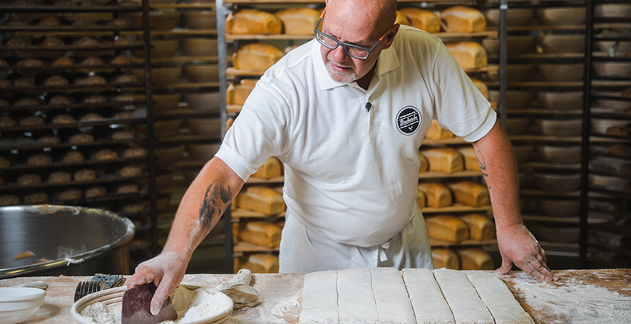 Bäckermeister Adi Brugger beim Teilen von Teig