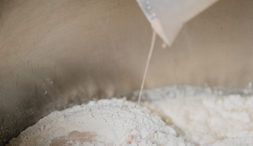 Frische aufgelöste Hefe wird in einen Topf voller Mehl gegossen