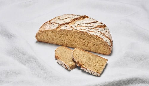 Ein Bio-Roggenbrot auf einem weißen Tischtuch