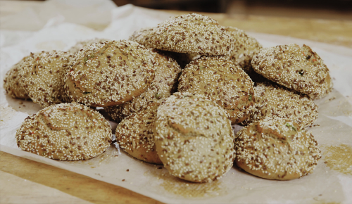 Ein Brett voller frisch gebackener Dinkel-Buchweizen-Weckerl