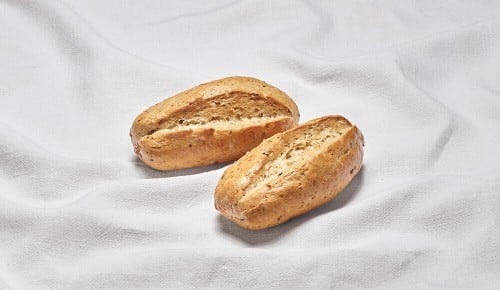Zwei Dinkelweckerl auf einem weißen Tischtuch