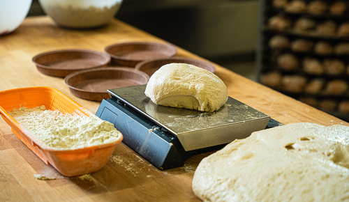 Frischer Focaccia-Teig beim Portionieren auf einer Waage