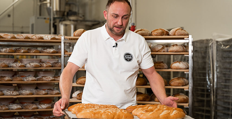 INTERSPAR-Bäcker Sascha Prehofer mit einem Blech voller Baguettes