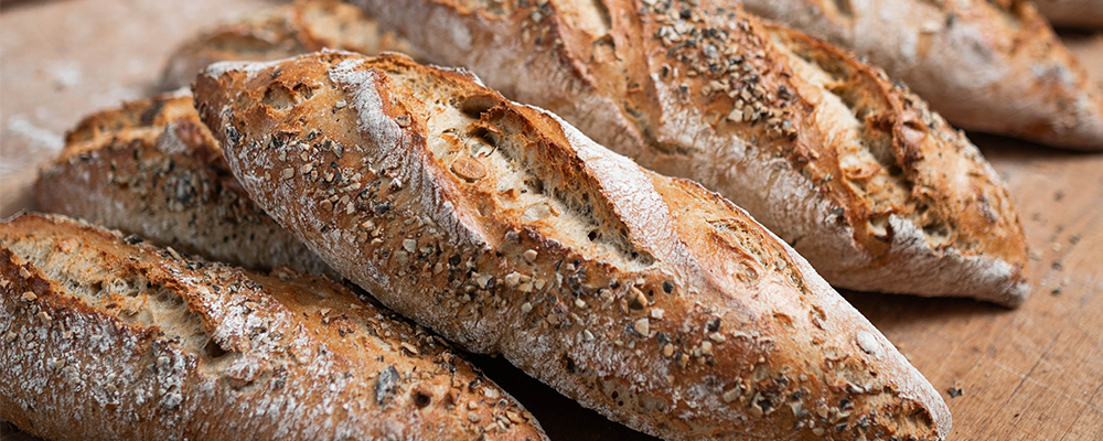 Ein frisch gebackenes, krosses Kürbisbrot auf einem Holzbrett