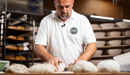 Ein Bäcker beim Portionieren von Teig-Stücken