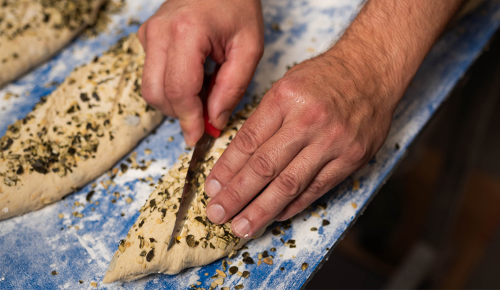 Frische Kürbiskernbrot-Teiglinge beim Einschneiden