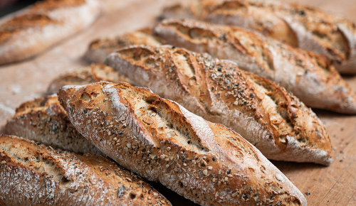Ein frisch gebackenes, krosses Kürbisbrot auf einem Holzbrett