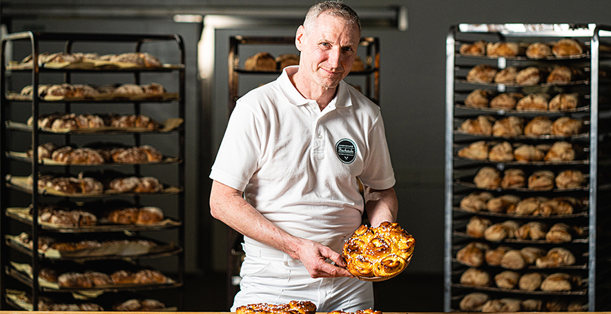 Bäckermeister Martin Broger mit seinem INTERSPAR Bäckerliebling, der Topfenblume