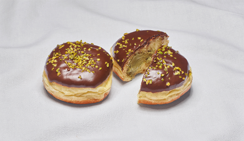 Ein Pistazien-Krapfen aus der INTERSPAR-Backstube auf einem weißen Tuch