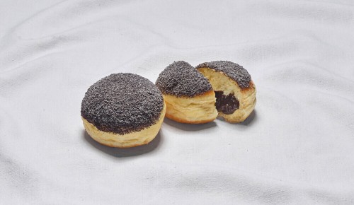 Ein in zwei Hälften geteilter Powidlkrapfen auf einem weißen Tuch
