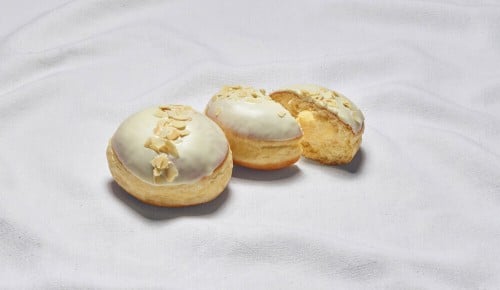Ein in zwei Hälften geteilterVanillekrapfen auf einem weißen Tuch