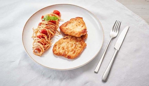 Eine Portion Spaghetti mit Tomatensauce und Röstiauf einem Teller