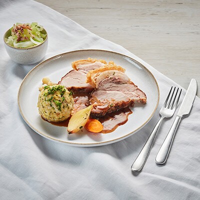 Ein Schweinsbraten mit Knödel und einer Portion Krautsalat
