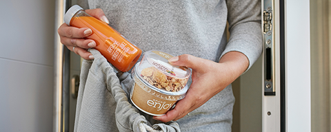 Eine Person mit zwei SPAR Enjoy-Produkten in der Hand