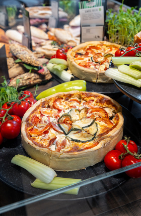 Eine frische Quiche mit verschiedenen Toppings in einer Auslage