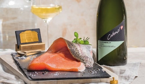 Ein Stück Lachs und ein Glas Weißwein auf einem Tisch