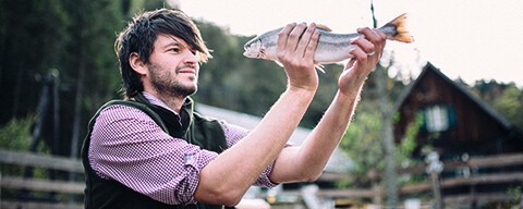 Ein Mitarbeiter von Michis Frische Fische mit einen Fisch in den Händen