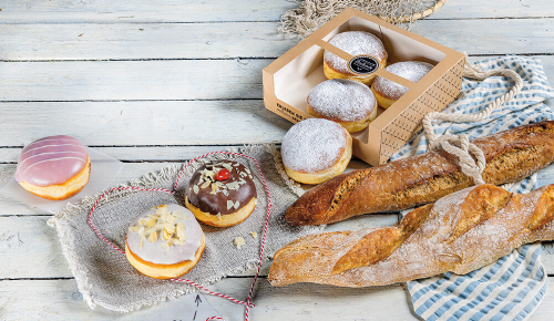 Baguettes und verschiedene Krapfen auf einem hellgrauen Untergrund 