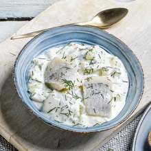 Heringssalat mit Dill in einem hellblauen Schälchen
