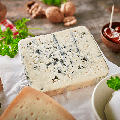 Ein Stück edler Blauschimmelkäse auf einem weißen Papier