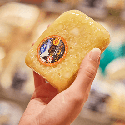 Ein Stück in Plastikfolie verpackter Sauermilchkäse 