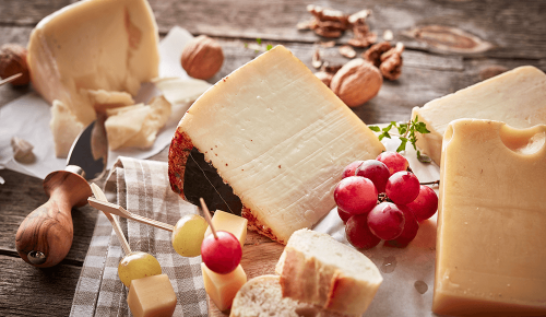 Reifer Hartkäse mit Weintrauben auf einem Holzbrett