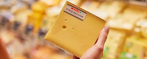 Eine Person hält einen SPAR Premium Hartkäse in der Hand