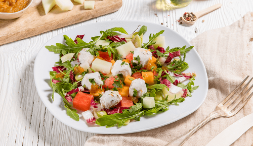 Ein bunter Salat mit Ziegenkäse, Salatblättern und Melone
