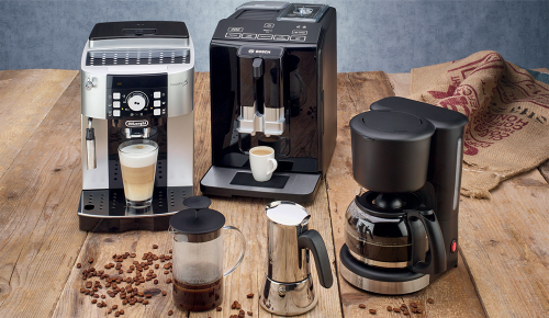 Mehrere verschiedene Kaffeemaschinen auf einem Holzuntergrund