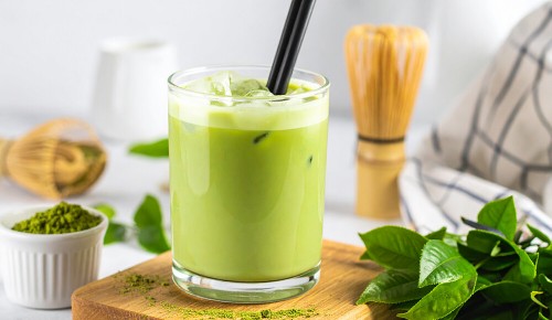 Ein Matcha-Latte mit einem Strohhalm in einem großen Glas