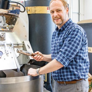 Ein Mitarbeiter von Alt Wien Kaffee an einer Kaffee-Röstmaschine